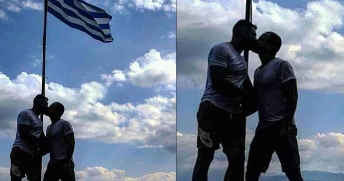 Εικόνες ντροπής παραμονές εθνικής επετείου: Αξιωματικός της ελληνικής αστυνομίας φιλιέται με μετανάστη μπροστά στην Ελληνική σημαία
